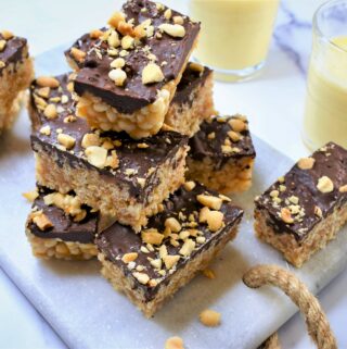 rice crispy treats with dark chocolate and peanut butter on white marble countertop