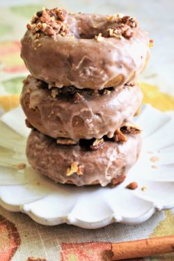 a stack of three baked pumpkin donuts on dessert plate