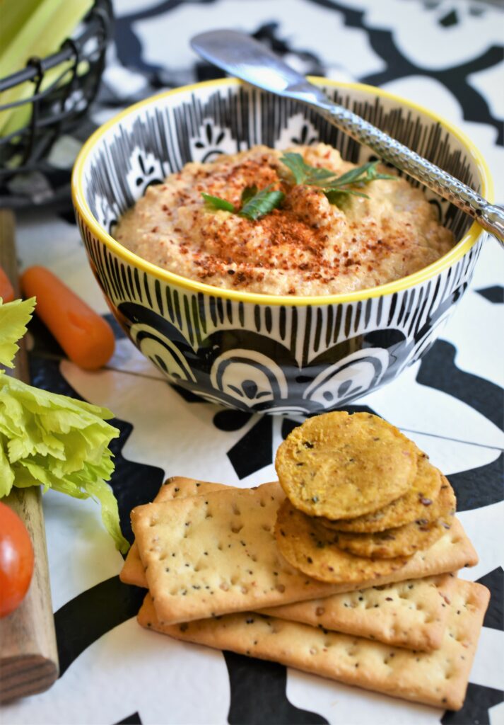 up close image of chipotle almond dip in black and white dip bowl with metal spread and crackers