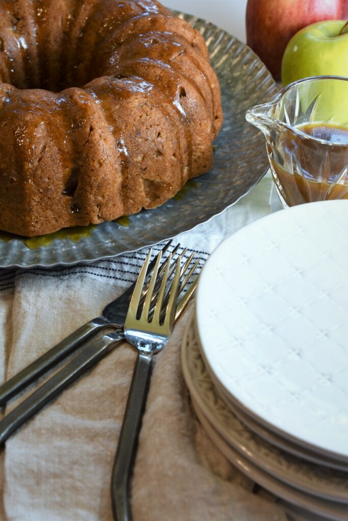 vegan apple Bundt cake ready to serve with black iron forks and country plates 