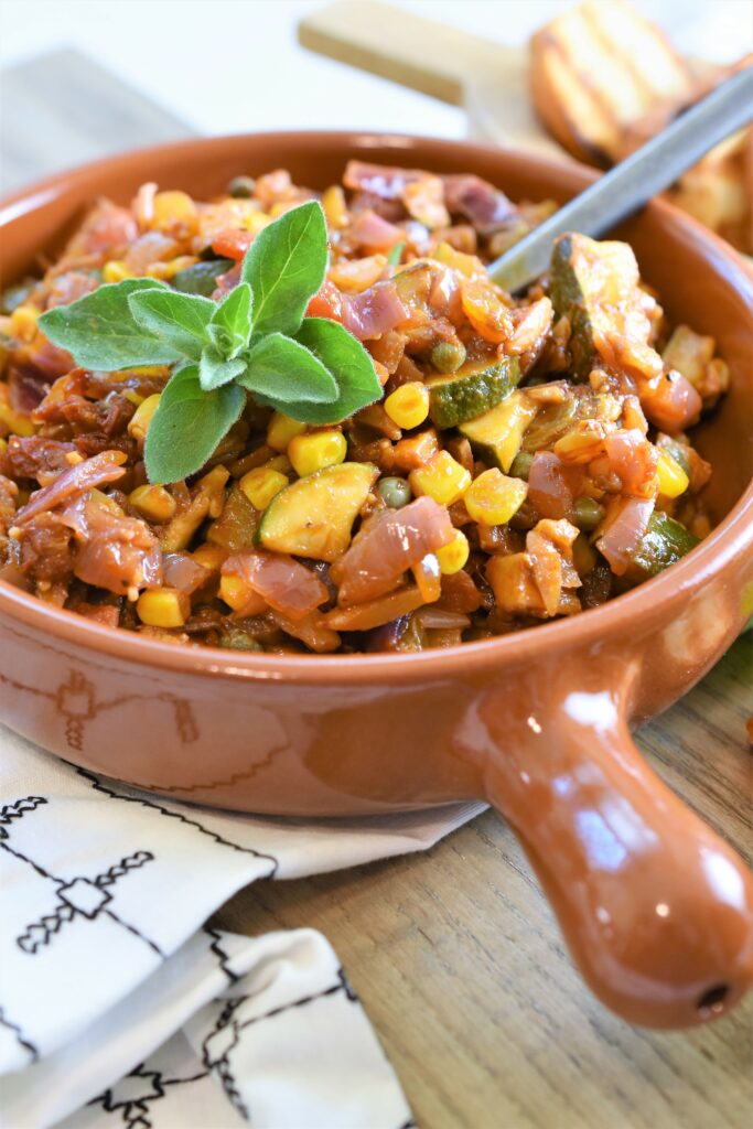 Sicilian zucchini corn gusto in bowl garnished with fresh oregano 