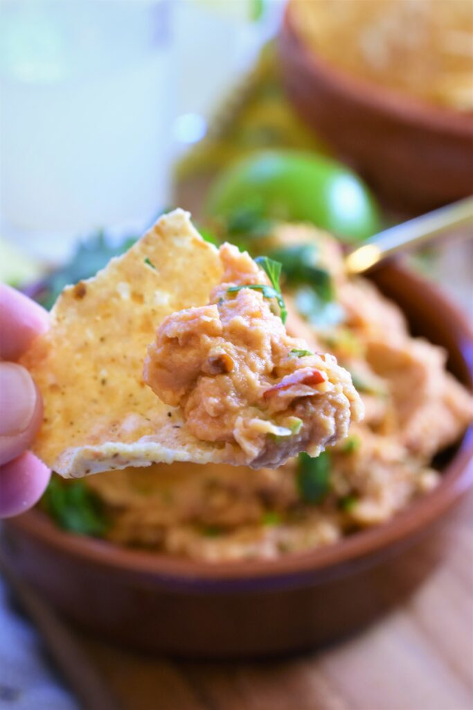 up close picture of tortilla chip with scooped up portion of spiciness  