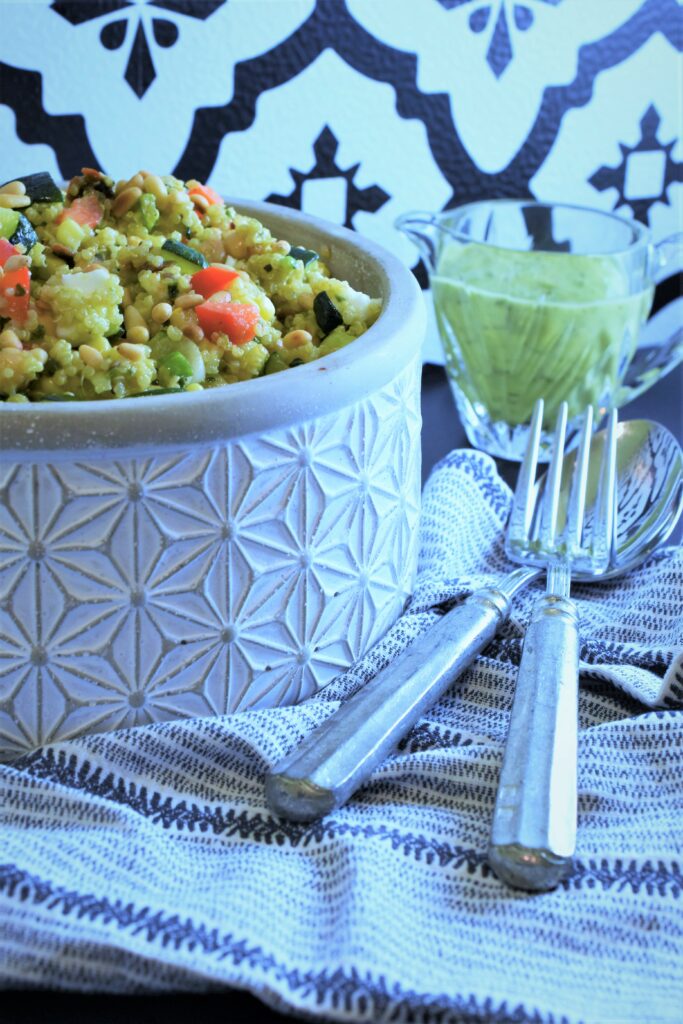 side of basil vinaigrette with bowl of quinoa salad