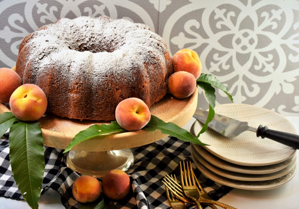 stack of empty dessert plates with cake serving utensil next to whole bundt cake