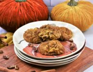 pumpkin pecan cookies on a stack of autumn inspired plates on cutting board with velvet pumpkins in the background