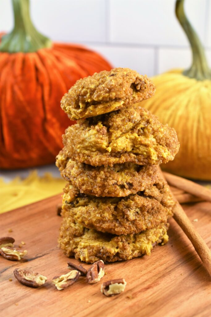 stack of 5 fall cookies on wood board with cinnamon sticks