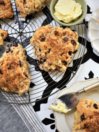 overhead image of vegan apple and cranberry scones with walnuts on round wire vintage cooling rack
