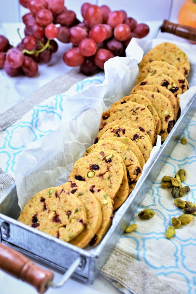 cranberry pistachio shortbread crackers in galvanized tin with parchment paper