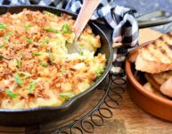 baked onion spread in frying pan on cutting board with grilled toasts