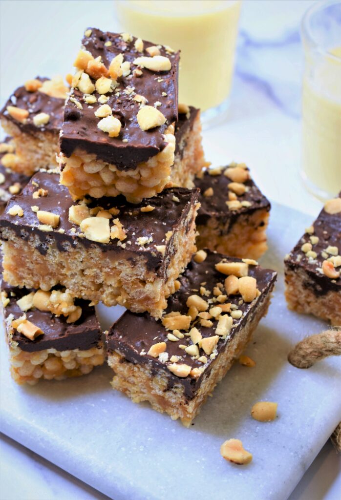 stacked and piled high krispy rice treats with peanut butter and chocolate